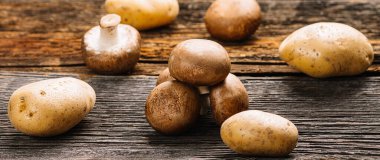 Eski ahşap arka planda birkaç taze şampiyon mantarı, seçici odaklanma