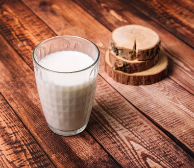 Eski ahşap bir masada büyük bir bardak süt, süt ürünleri, stok fotoğrafı..