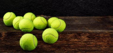Ahşap arka planda sarı tenis topları, metin, spor ve yarışma konsepti için alan