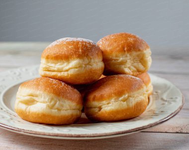 Avusturya ve Alman çörekleri - krapfen, faşingskrapfen. Kremalı Berlinli. Beyaz tabakta. Seçici odak.