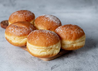 Avusturya ve Alman çörekleri ya da krapfen, faşingskrapfen. Kremalı Berlinli. Gri arkaplanda. Seçici odak.