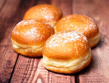 Avusturya ve Alman çörekleri ya da krapfen, faşingskrapfen. Kremalı Berlinli. Ahşap arka planda. Seçici odak.