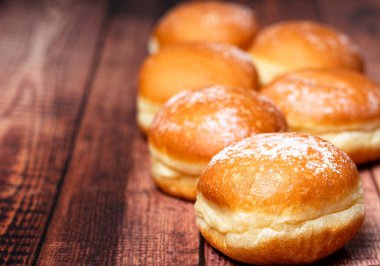Avusturya ve Alman çörekleri ya da krapfen, faşingskrapfen. Kremalı Berlinli. Ahşap arka planda. Seçici odak.