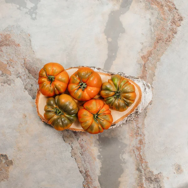 A group of Costoluto big tomatoes on a grey background, rustic concept, stock photo