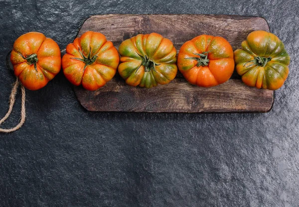 A group of Costoluto big tomatoes on a wooden background, rustic concept, stock photo