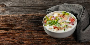 Geleneksel Rus soğuk çorbası okroshka taze patates, salatalık, domates, haşlanmış yumurta ve kefir. Düz zemin, ahşap zemin, üst manzara