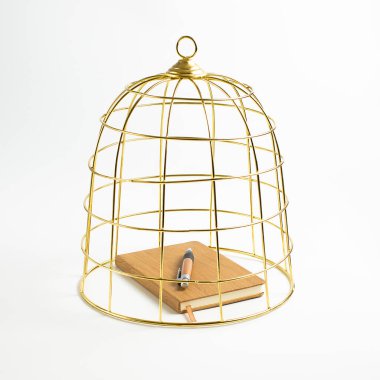 Büyük altın kuş kafesi, beyaz arka planda defter ve kalem, konsept, stok fotoğrafı