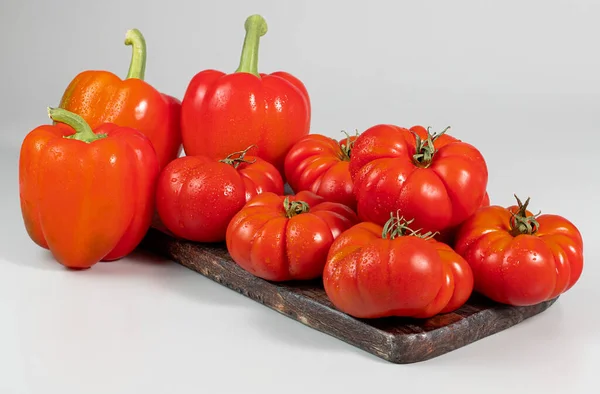A group of Costoluto big tomatoes and paprika on a white background