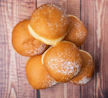 Avusturya ve Alman çörekleri veya krapfen. Kremalı Berlinli. Faschingskrapfen. Ahşap arka planda. Seçici odaklanma, üst görünüm, fırıncı kavramı.