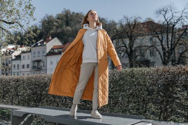 Şehirde yürüyen güzel, genç, şık bir kadın. Bahar havası, hayal kurmak ve beklemek, bir yaşam tarzı konsepti