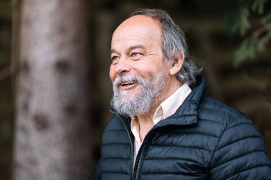 Yürüyüşü sırasında gülümseyen, kendinden emin, yakışıklı, olgun bir adamın portresi.