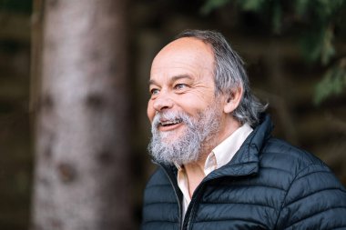 Yürüyüşü sırasında gülümseyen, kendinden emin, yakışıklı, olgun bir adamın portresi.