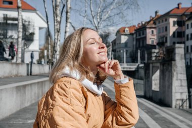 Şehirde yürüyen güzel, genç, şık bir kadın. Bahar havası, hayal kurmak ve beklemek, bir yaşam tarzı konsepti
