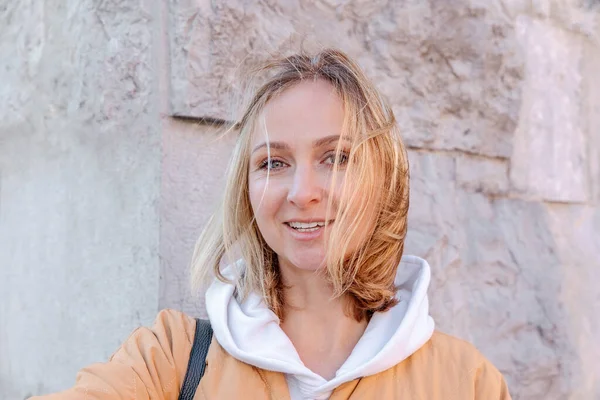 Şehirde yürüyen güzel, genç, şık bir kadın. Bahar havası, hayal kurmak ve beklemek, bir yaşam tarzı konsepti