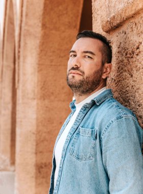 Kot ceketli yakışıklı bir hippi portresi. Sokaktaki büyük bir şehirde bir adam, yaşam tarzı konsepti.