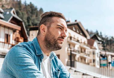 Kot ceketli yakışıklı bir hippi portresi. Sokaktaki büyük bir şehirde bir adam, yaşam tarzı konsepti.