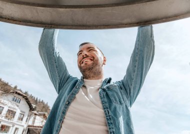 Sokakta büyük bir şehirde kot ceketli yakışıklı bir hippi portresi, yaşam tarzı konsepti.