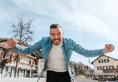 Sokakta büyük bir şehirde kot ceketli yakışıklı bir hippi portresi, yaşam tarzı konsepti.