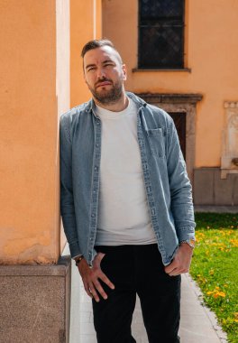 Sokakta büyük bir şehirde kot ceketli yakışıklı bir hippi portresi, yaşam tarzı konsepti.