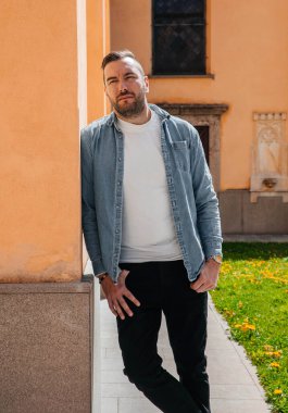 Kot ceketli yakışıklı bir hippi portresi. Sokaktaki büyük bir şehirde bir adam, yaşam tarzı konsepti.