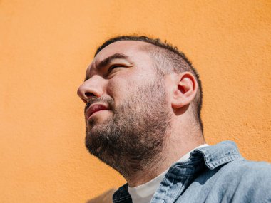 Kot ceketli yakışıklı bir hippi portresi. Sokaktaki büyük bir şehirde bir adam, yaşam tarzı konsepti.