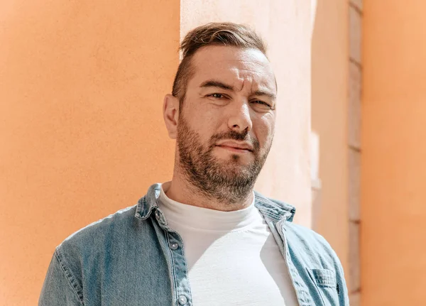 stock image Portrait of a handsome hipster man in a jean jacket. A man in a big city on the street, a life style concept