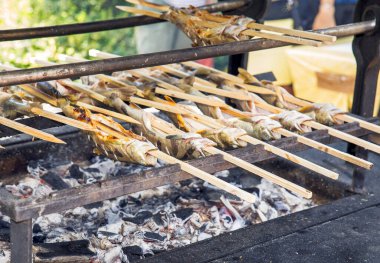 Açık havada pişirmek için açık ateşte ızgara balık. Geleneksel barbekü besin konseptini betimliyor.