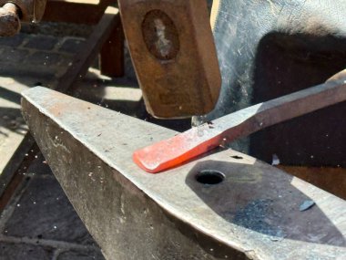 Blacksmith using hammer to shape hot metal on anvil, crafting iron, steel, forge, heavy metalwork, process of traditional craftsmanship, smithing, handwork, metal shaping, blacksmith concept clipart