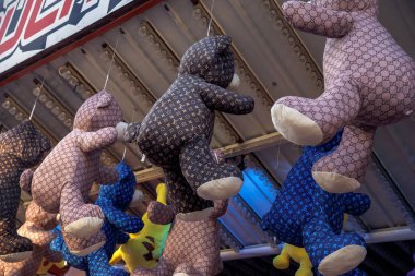 Doldurulmuş ayılar lunapark standında asılı duruyor, oyuncak ayılar, peluş oyuncaklar, karnaval ödülleri, dekoratif doldurulmuş hayvanlar konsepti.