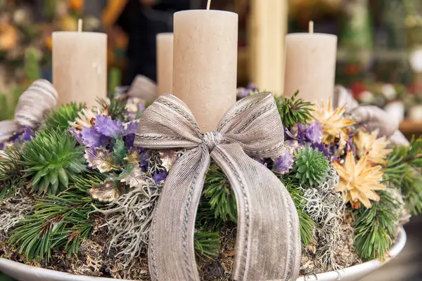 stock image Elegant Christmas wreath centerpiece with candles, ribbons, and decorative pine elements, an ideal holiday decoration concept