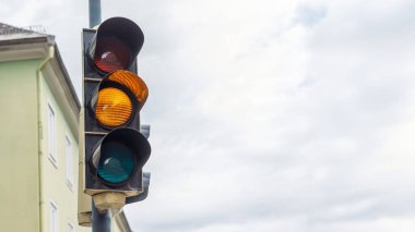 Şehir kavşağında kırmızı, kehribar ve yeşil ışık gösteren trafik sinyali, şehir ulaşımı kavramı