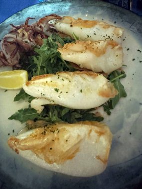 Limonlu taze roka yatağında ızgara kalamar.