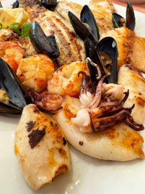 Grilled seafood platter with mussels, squid, and shrimp on plate clipart