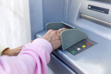Bir ATM kullanan kişi: güvenli bankacılık terminalinin pimine el kamerasının yakın çekimi