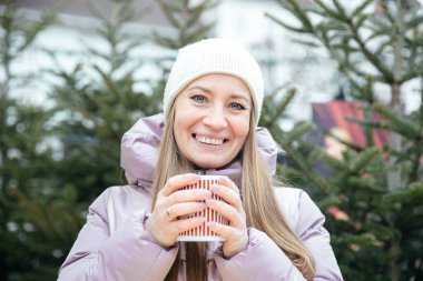 Kışın harikalar diyarında sıcak içecekten hoşlanan bir kadın