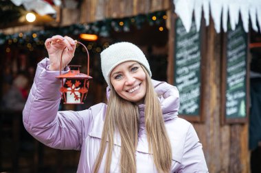 Bayram pazarında fener tutan neşeli kadın.