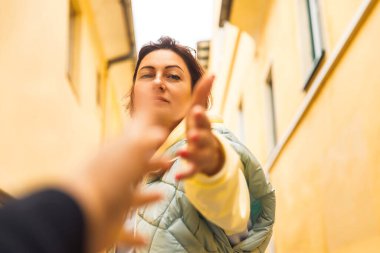 Sarı şehir duvarları arasında uzanan bir kadın bağlantıyı ve yalnızlığı yakalıyor.