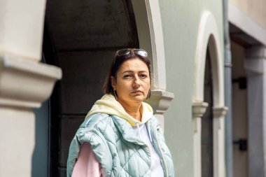 Kendine güvenen kadın kemerli binanın yanında duruyor.