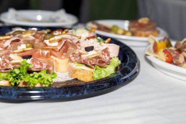 Taze sebzeli ve sade ekmekli zeytinli gurme et ve peynir tabağı.