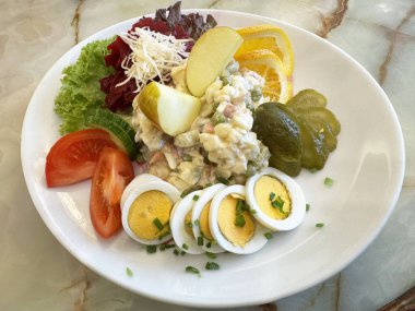 Yumurtalı taze patates salatası, marul, domates ve meyveli garnitür..