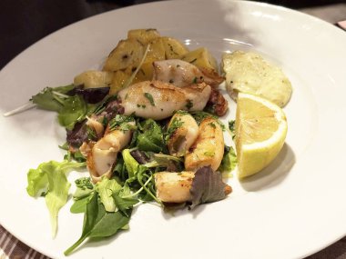 Kızarmış kalamar, patates ve limonlu garnitür..