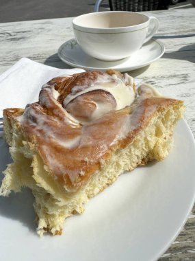 Kafe ortamında vişneli ve kremalı siyah orman pastası dilimi.