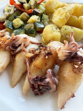 Izgara kalamar, kızarmış kabak, biber ve baharatlı patates..