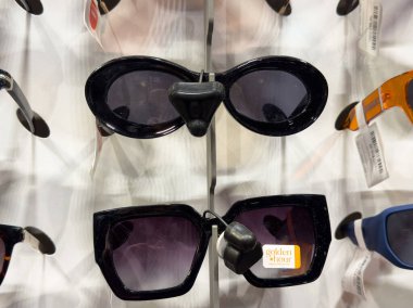 Black sunglasses display with various styles and shapes on a stand. clipart