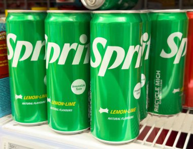 Yeşil ambalaj ve limon aromalı soda kutuları vitrinde.