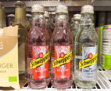 Schweppes içecek şişeleri raflarda sergileniyor.