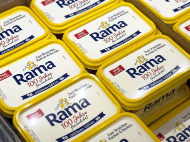 Vitrinde sarı kapaklı Rama margarin küvet paketi.