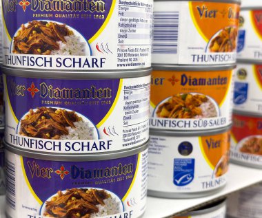 Alman süpermarketinde baharatlı etiketli konserve ton balığı görüntüsü.