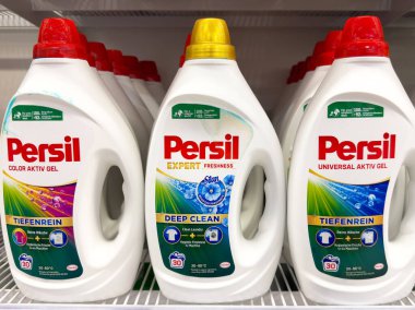 Rafta çeşitli özellikleri olan Persil deterjan şişeleri.