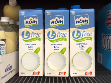 Nom lactose-free milk on shelf display in grocery store. clipart